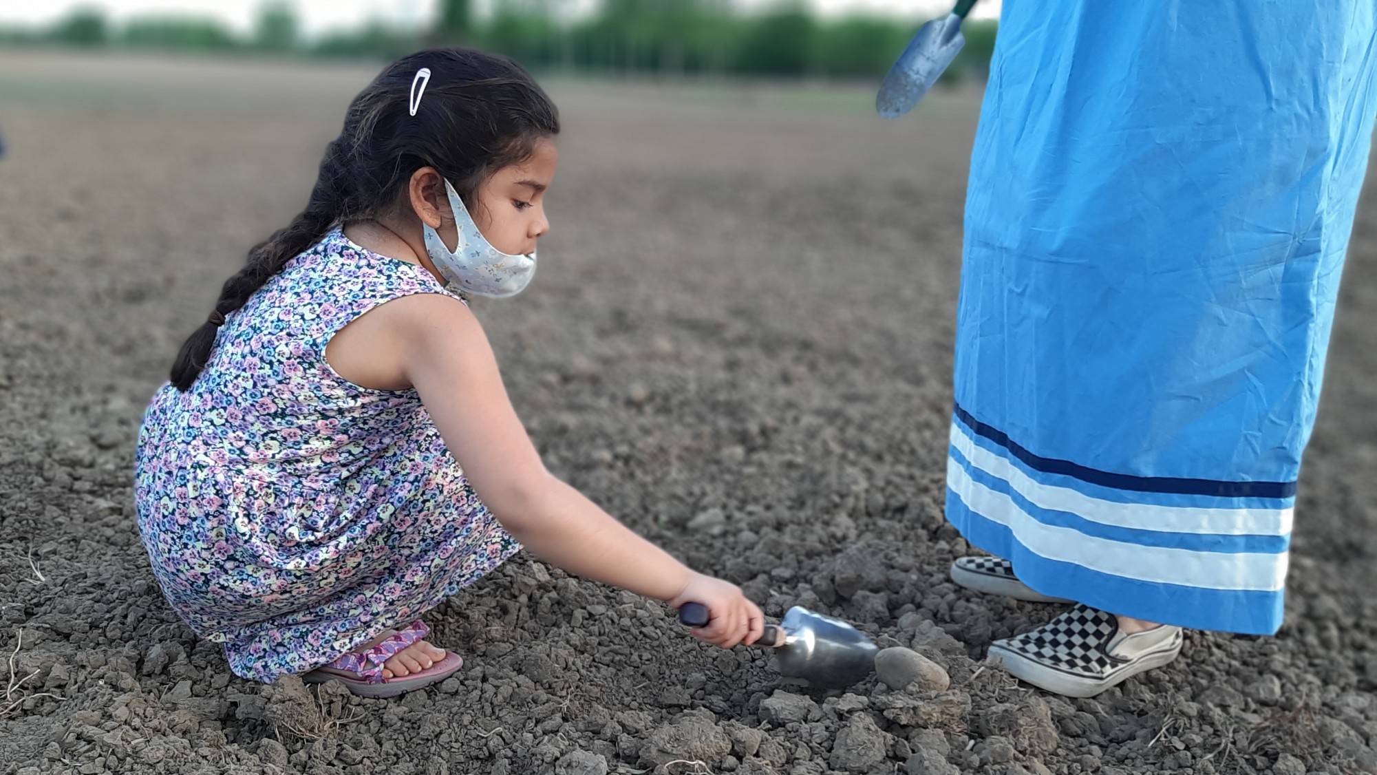Young Miriam Chouhan plants seeds on the land that was donated by Pfenning’s Organic Farm in New Hamburg. She is supervised by Indigenous Food Sovereignty Collective Waterloo Region’s Bekah Brown. (Photo credit: Nigel Gordijk)